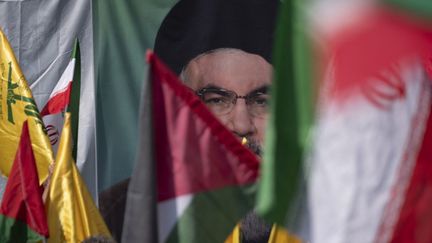 Des drapeaux palestiniens et iraniens devant un portrait de Hassan Nasrallah, à Téhéran le 27 septembre 2024 (MORTEZA NIKOUBAZL / NURPHOTO)